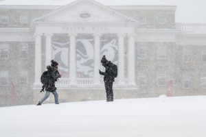 UW students walk in front of Bascom Hall during an early-season snowstorm.