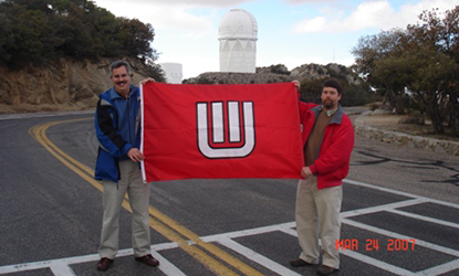On the Board of Visitors trip to Kitt Peak, two men hold up a red flag.
