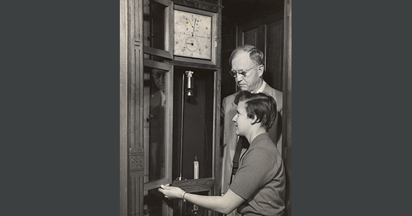 Photo of a man and woman opening up a clock.
