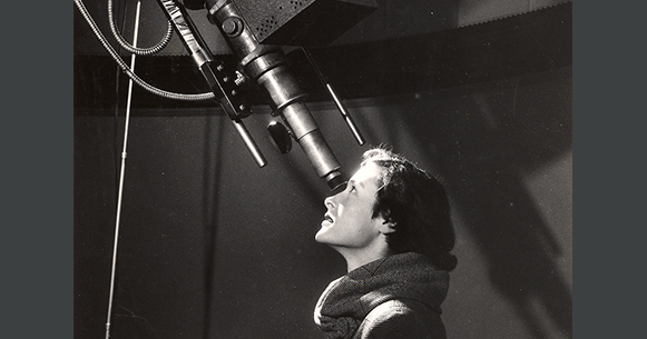 Woman looking into a telescope.