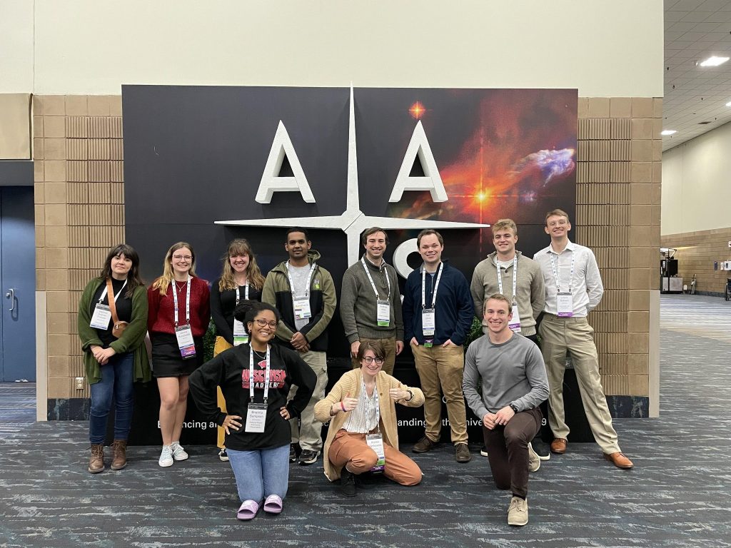 RADIAL students pose for a photo in front of an American Astronomical Society sign.