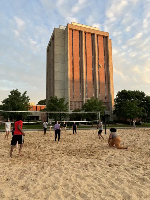 RADIAL students play sand volleyball on campus at sunset.