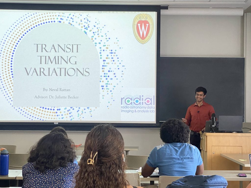 Neval stands in front of the title slide of his final presentation, projected onto a screen at the front of a classroom.