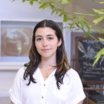 Martina Salichs Maidana poses for a headshot in a white button up shirt.